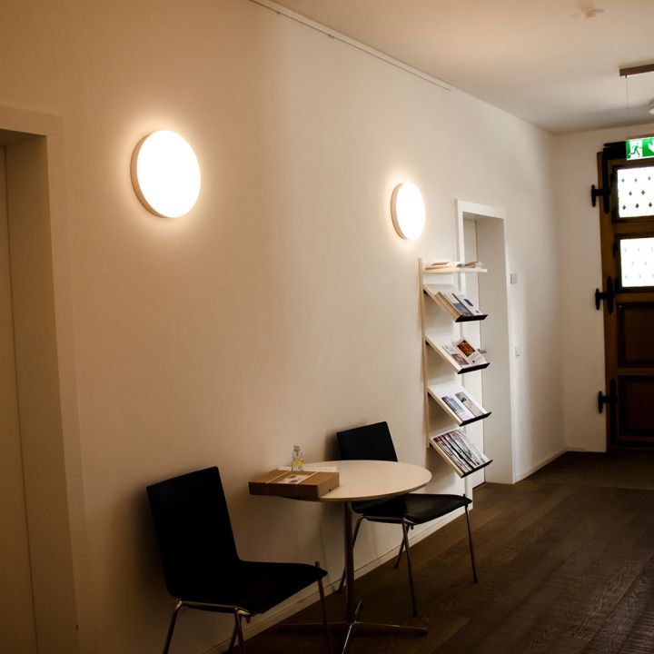 Gemütliche Sitzecke in einem Flur mit runden Wandleuchten.