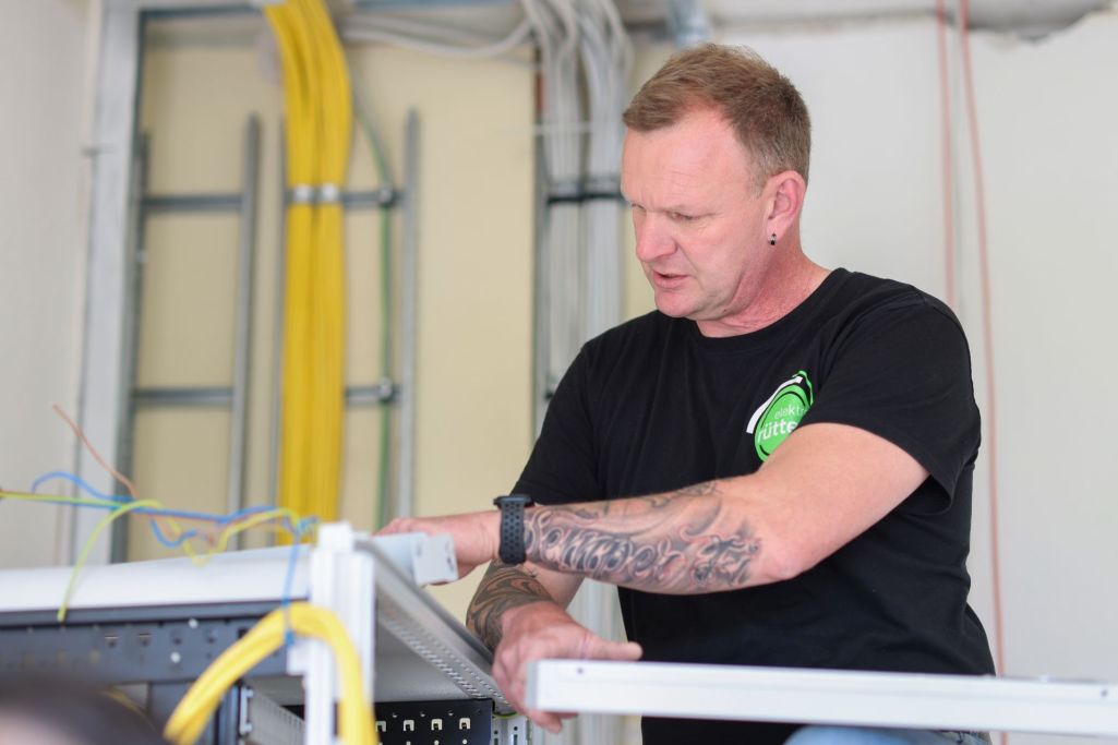 Ein Elektriker arbeitet konzentriert an einer elektrischen Anlage mit Kabeln.