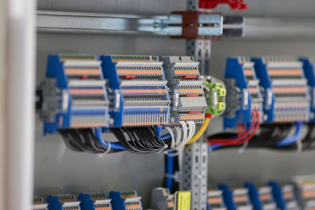 Ein Elektriker arbeitet konzentriert an einer elektrischen Anlage mit Kabeln.